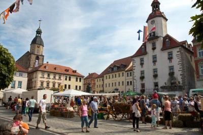 Bauernmarkt mit festlich geschmücktem Rathaus von Schmölln im Hintergrund